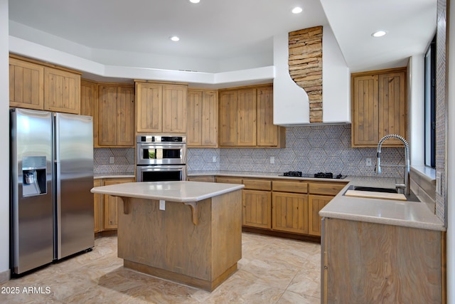 kitchen featuring sink, tasteful backsplash, a breakfast bar, a kitchen island, and stainless steel appliances