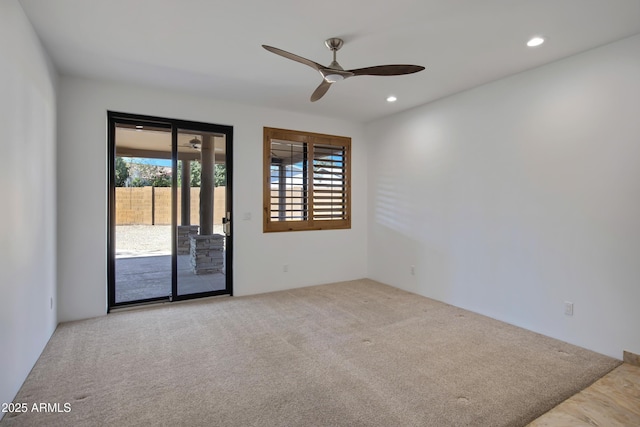 carpeted spare room featuring ceiling fan