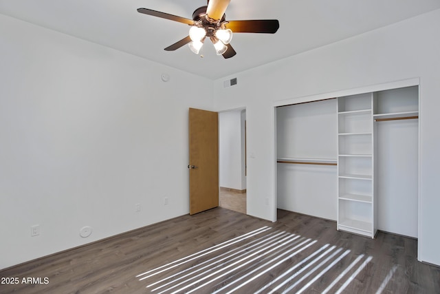 unfurnished bedroom featuring a closet, ceiling fan, and dark hardwood / wood-style flooring