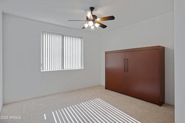 unfurnished bedroom with light colored carpet, a closet, and ceiling fan