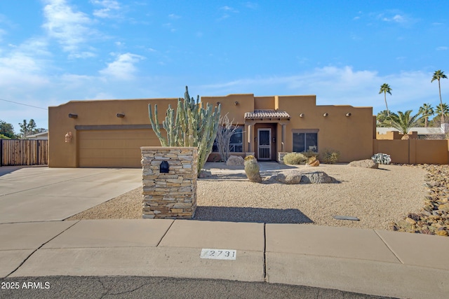 pueblo revival-style home featuring a garage