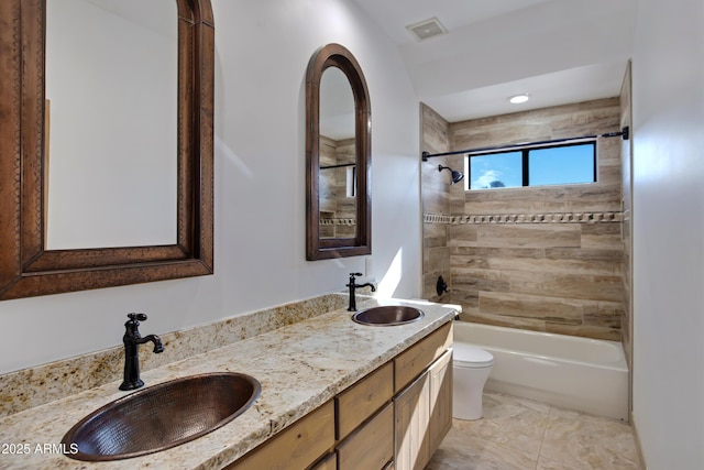 full bathroom featuring toilet, vanity, and tiled shower / bath combo