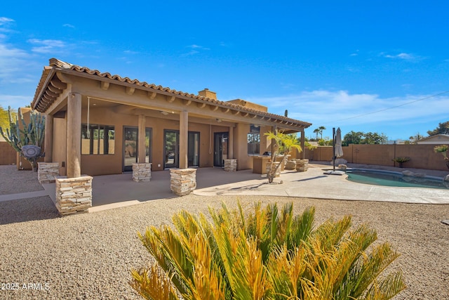 back of property featuring a fenced in pool and a patio area