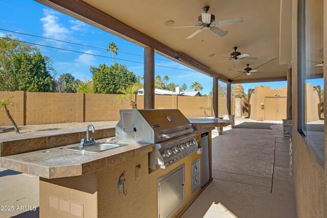 view of patio / terrace with sink, ceiling fan, an outdoor kitchen, and a grill