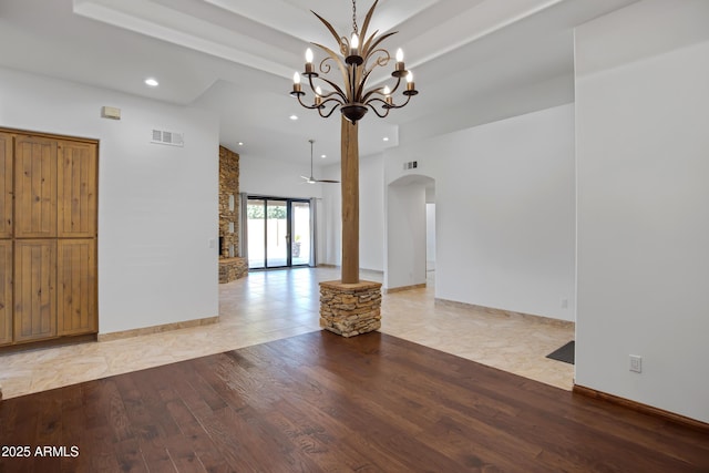 unfurnished living room featuring a fireplace, light hardwood / wood-style flooring, and an inviting chandelier