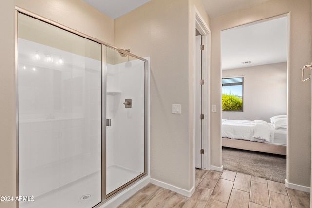 bathroom featuring hardwood / wood-style floors and a shower with door