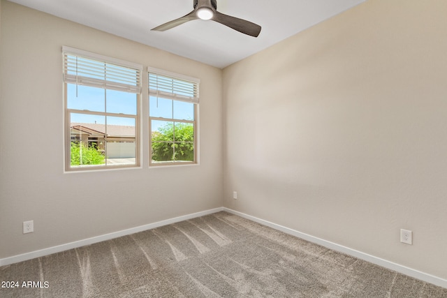 carpeted spare room featuring ceiling fan