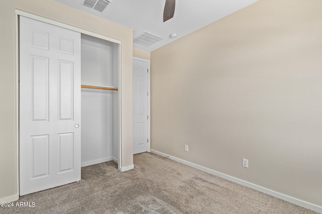 unfurnished bedroom with carpet flooring, ceiling fan, and a closet