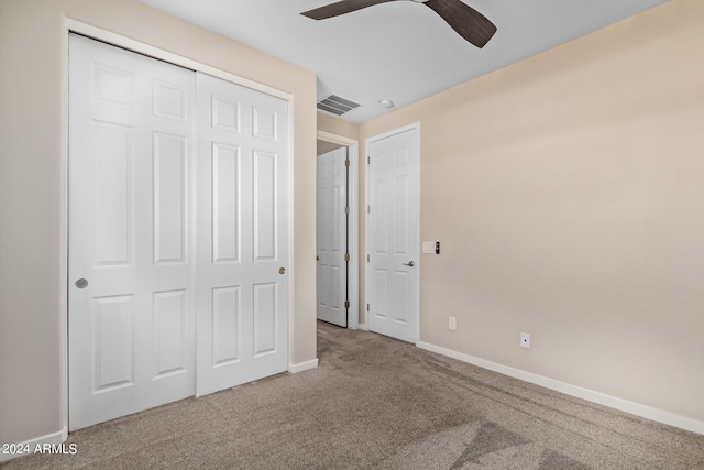 unfurnished bedroom with carpet flooring, ceiling fan, and a closet