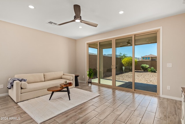 living room with light hardwood / wood-style flooring and ceiling fan