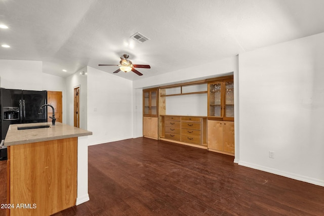 kitchen with dark wood-type flooring, black fridge, sink, vaulted ceiling, and ceiling fan