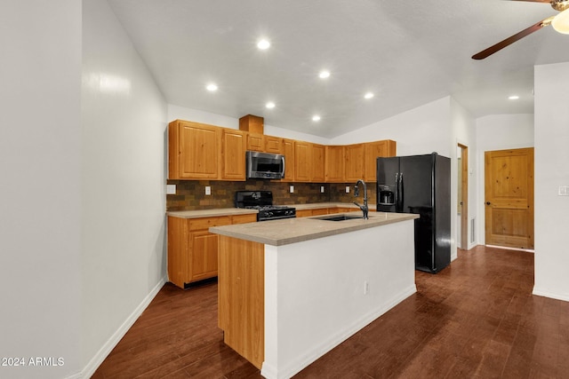 kitchen featuring sink, a kitchen island with sink, dark hardwood / wood-style floors, decorative backsplash, and black appliances