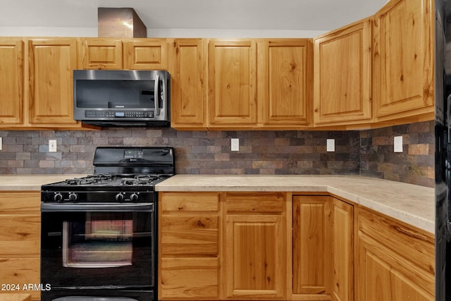 kitchen featuring decorative backsplash, light brown cabinetry, and black range with gas cooktop