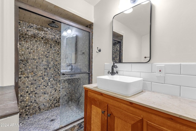 bathroom with vanity, a shower with door, and tasteful backsplash