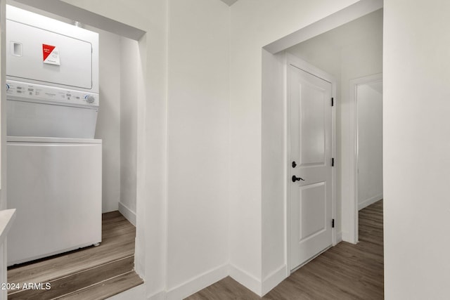 hall with hardwood / wood-style floors and stacked washer / dryer