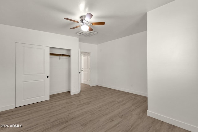 unfurnished bedroom with hardwood / wood-style floors, a closet, and ceiling fan