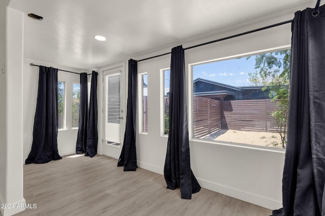 unfurnished room with light wood-type flooring and a wealth of natural light