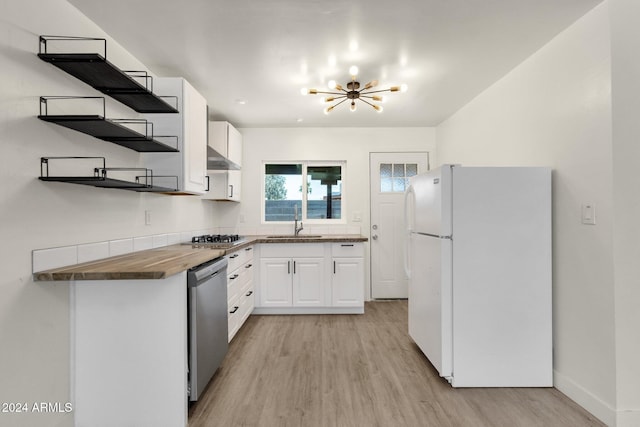 kitchen featuring wooden counters, light wood-type flooring, white cabinetry, stainless steel appliances, and a chandelier