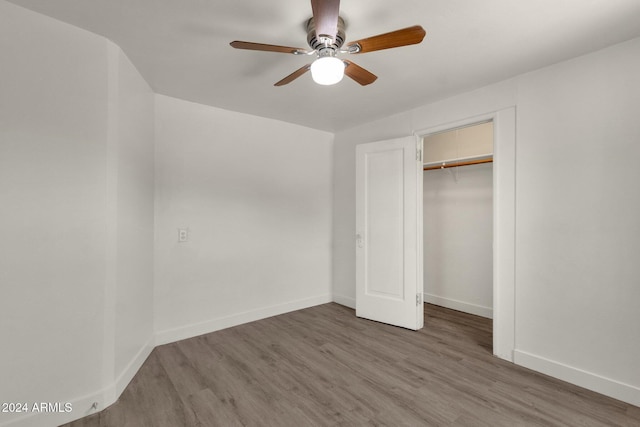 unfurnished bedroom with hardwood / wood-style floors, a closet, and ceiling fan