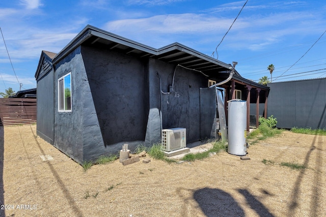 view of side of home with ac unit