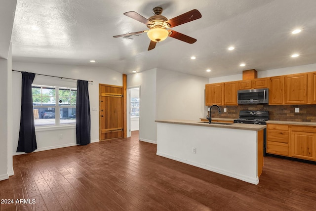 kitchen featuring black gas range, vaulted ceiling, dark wood-type flooring, and sink