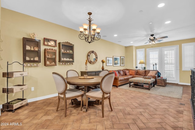 dining room with ceiling fan with notable chandelier and light parquet floors