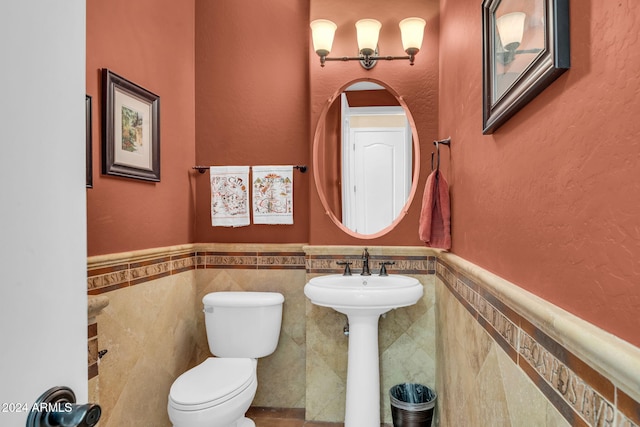 bathroom featuring tile walls and toilet