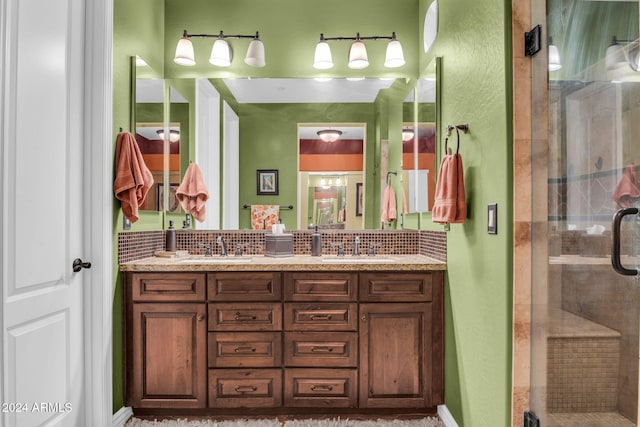 bathroom with tasteful backsplash, vanity, and a shower with door