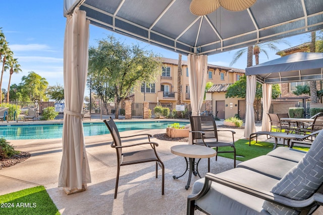 view of swimming pool with ceiling fan, a gazebo, and a patio