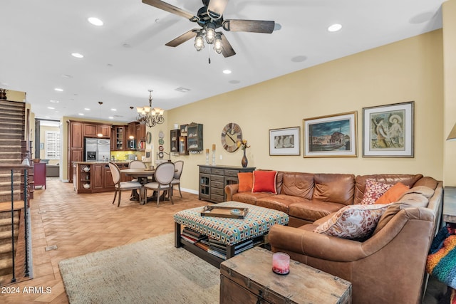 living room featuring ceiling fan with notable chandelier and light parquet flooring