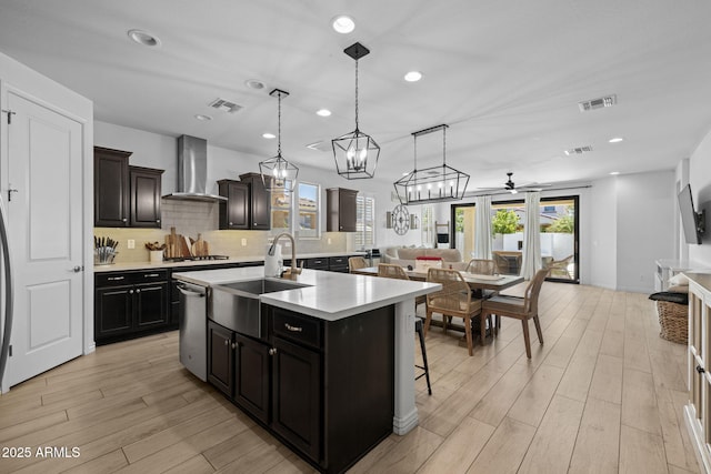 4346 S Synapse Dr, Mesa, AZ 85212 - kitchen featuring wall chimney exhaust hood, stainless steel dishwasher, gas stovetop, light countertops, and open floor plan