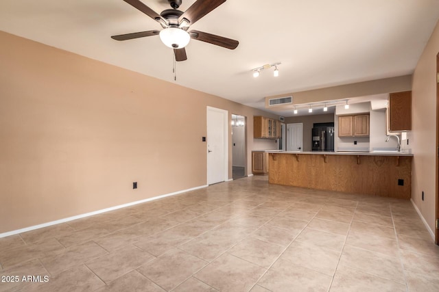 3010 E Cortez St, Phoenix, AZ 85028 - unfurnished living room with a sink, track lighting, a ceiling fan, baseboards, and light tile patterned floors