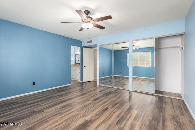 3010 E Cortez St, Phoenix, AZ 85028 - unfurnished bedroom with two closets, baseboards, dark wood finished floors, and a ceiling fan