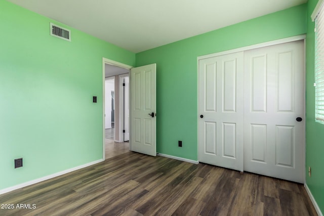 3010 E Cortez St, Phoenix, AZ 85028 - unfurnished bedroom with dark wood finished floors, baseboards, and a closet