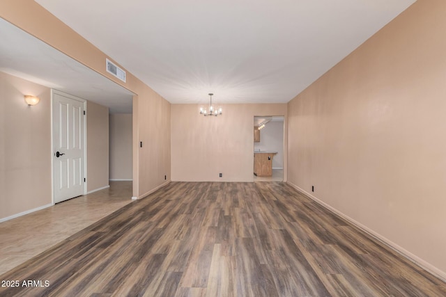 3010 E Cortez St, Phoenix, AZ 85028 - empty room with a chandelier, wood finished floors, and baseboards