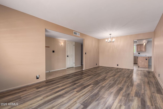 3010 E Cortez St, Phoenix, AZ 85028 - unfurnished living room featuring a chandelier, dark wood-type flooring, and baseboards