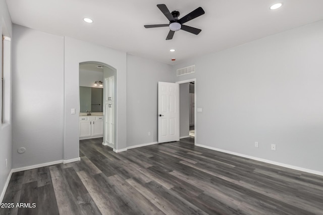 20919 E Desert Hills Blvd, Queen Creek, AZ 85142 - unfurnished bedroom with arched walkways, dark wood-style floors, recessed lighting, connected bathroom, and a ceiling fan