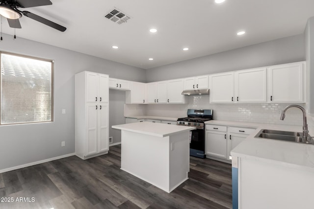 20919 E Desert Hills Blvd, Queen Creek, AZ 85142 - kitchen with stainless steel range with gas stovetop, under cabinet range hood, a center island, a ceiling fan, and dark wood-style flooring