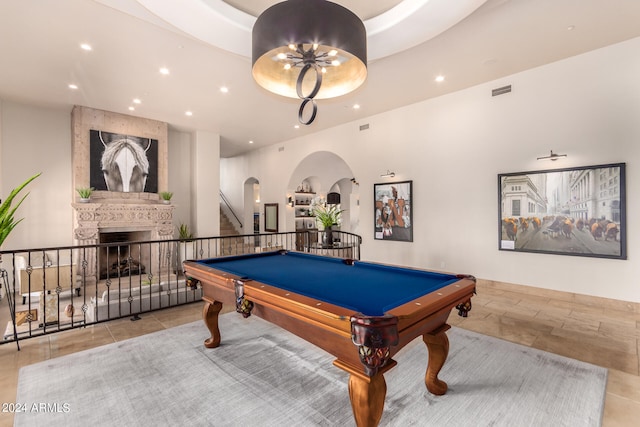 recreation room with a large fireplace, a tray ceiling, light tile patterned flooring, and billiards