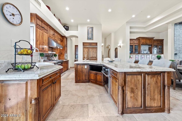 kitchen with visible vents, a large island, oven, under cabinet range hood, and recessed lighting