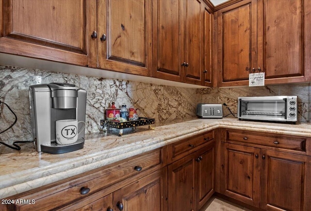 kitchen with brown cabinets, decorative backsplash, and a toaster