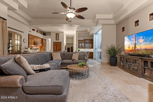 living area featuring ceiling fan and arched walkways