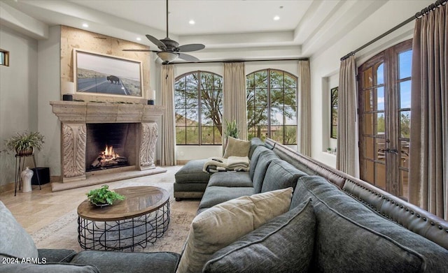 sunroom featuring ceiling fan and a fireplace