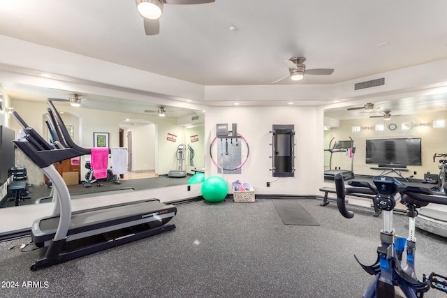 exercise room with arched walkways, ceiling fan, baseboards, and visible vents