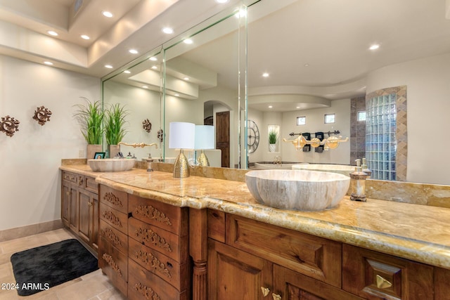bathroom with double vanity, baseboards, tile patterned flooring, and recessed lighting