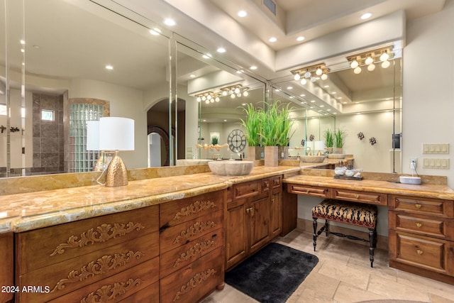 bathroom with vanity, a shower, and a tray ceiling