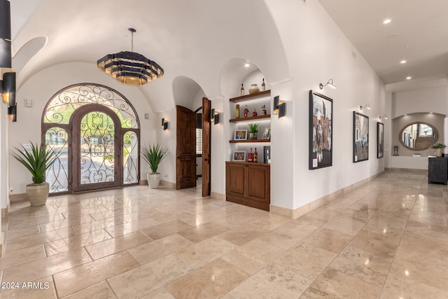 foyer entrance featuring a chandelier and a high ceiling