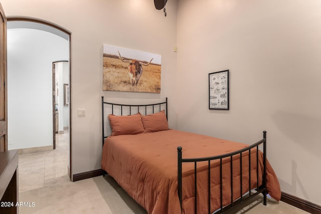 bedroom with arched walkways and baseboards
