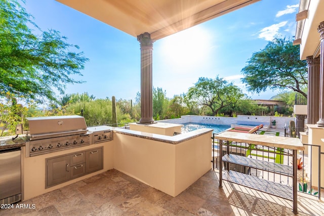 view of patio / terrace with exterior kitchen, area for grilling, and a balcony