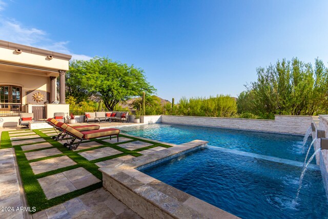 view of swimming pool with a patio, an outdoor living space, a hot tub, and pool water feature